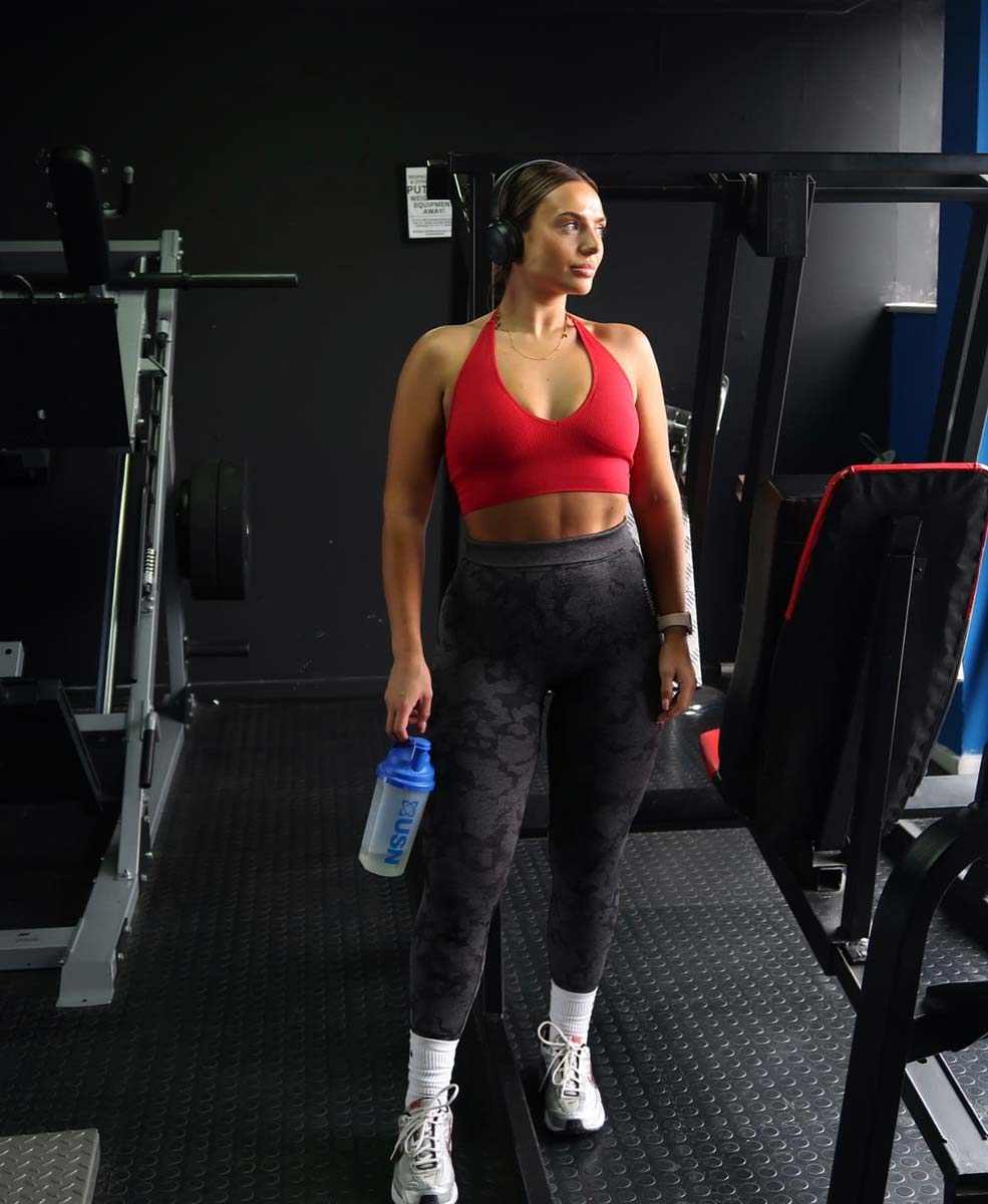 The coach is posing at the gym.