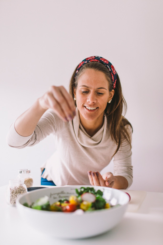 Treinadora a preparar uma salada.