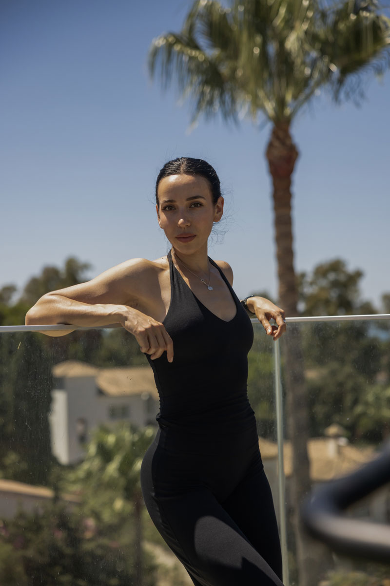 The coach is posing while wearing black clothes.