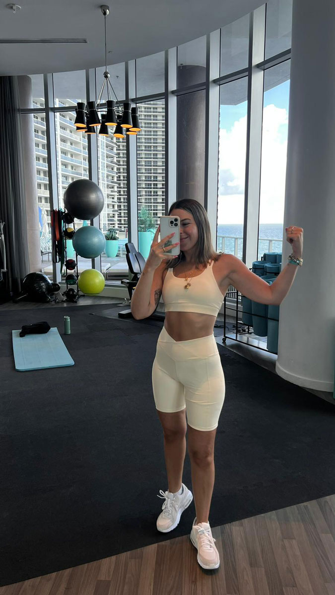 La entrenadora está posando en el gimnasio.