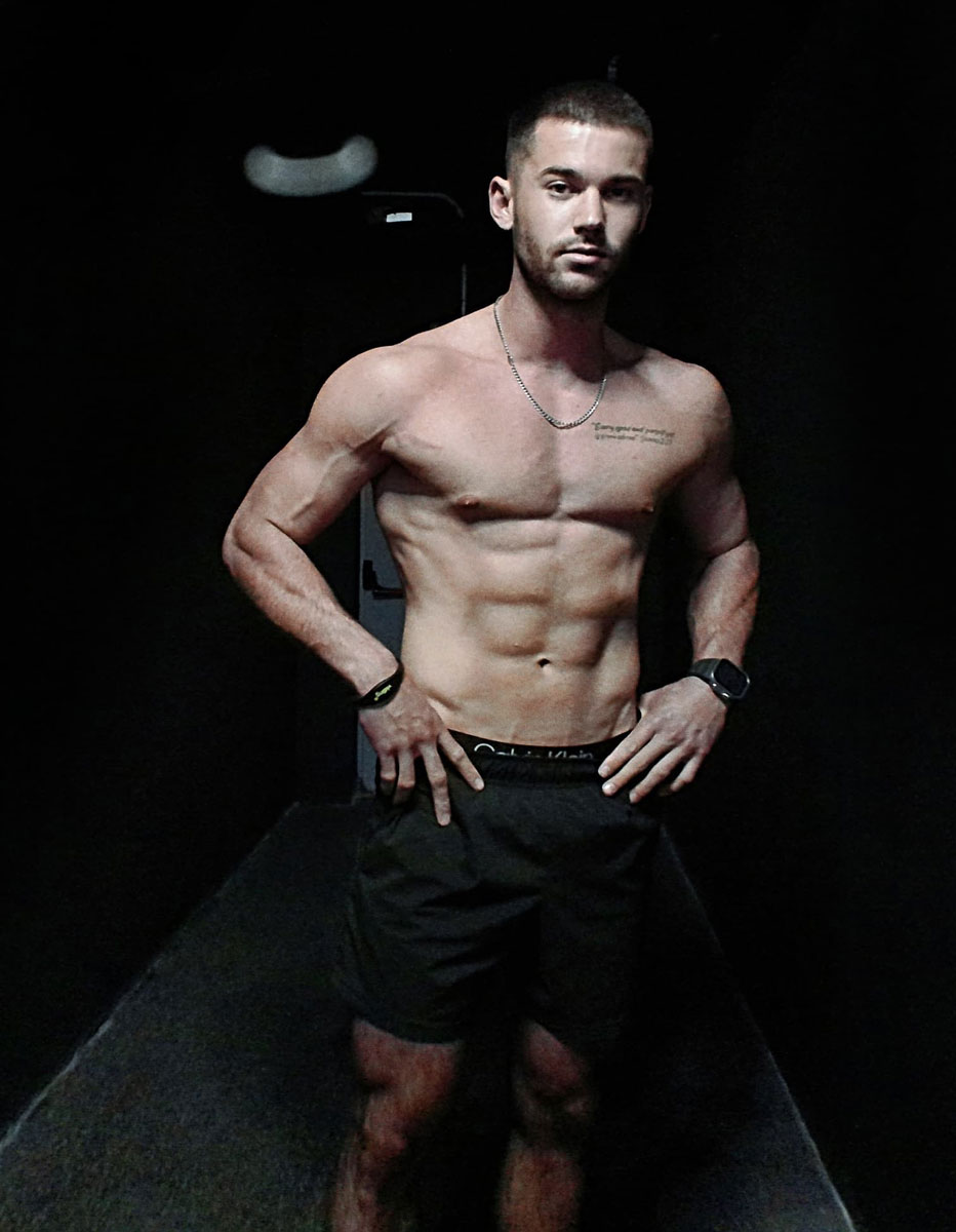 The coach is posing at the gym.