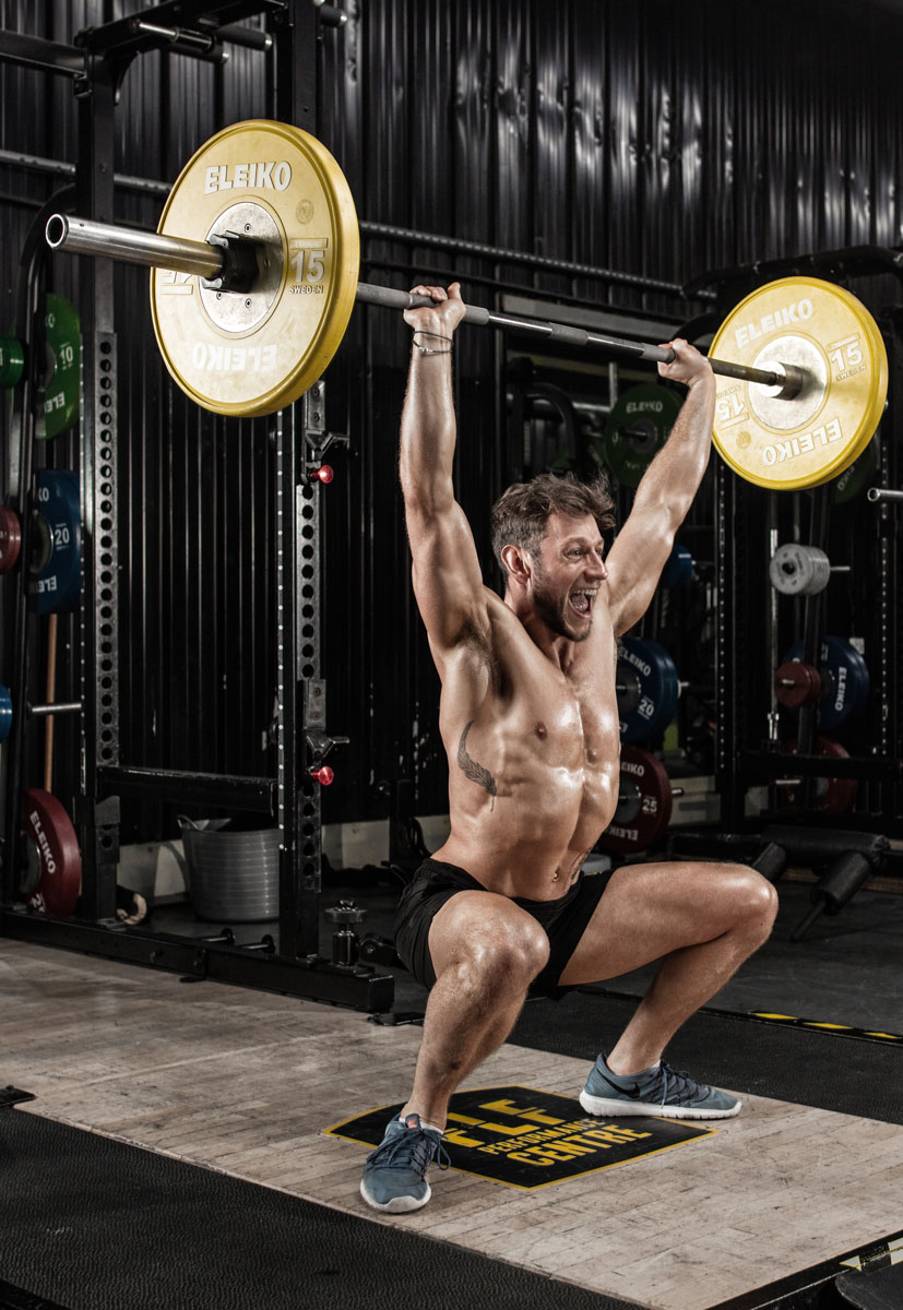 The coach is doing the weights at the gym.