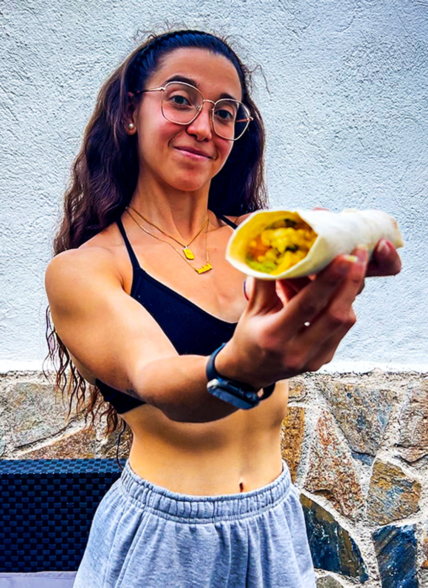 El entrenador sostiene un burrito de desayuno. El entrenador sostiene un burrito de desayuno.