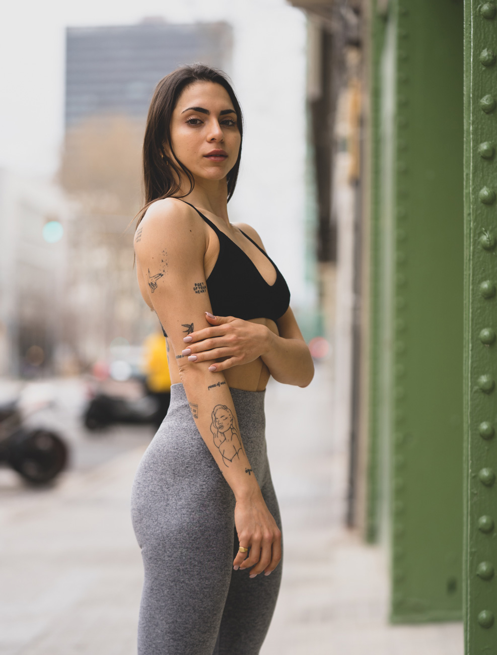 Entrenadora posando en leggins grises y top negro.