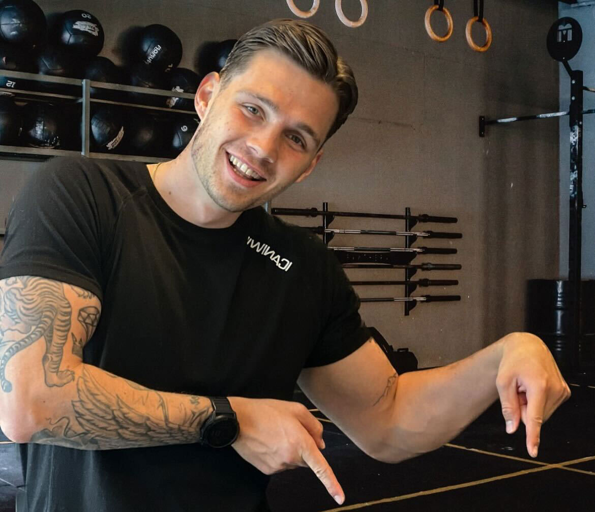 Trener etter en treningsøkt, smilende i svart-hvitt-bilde.