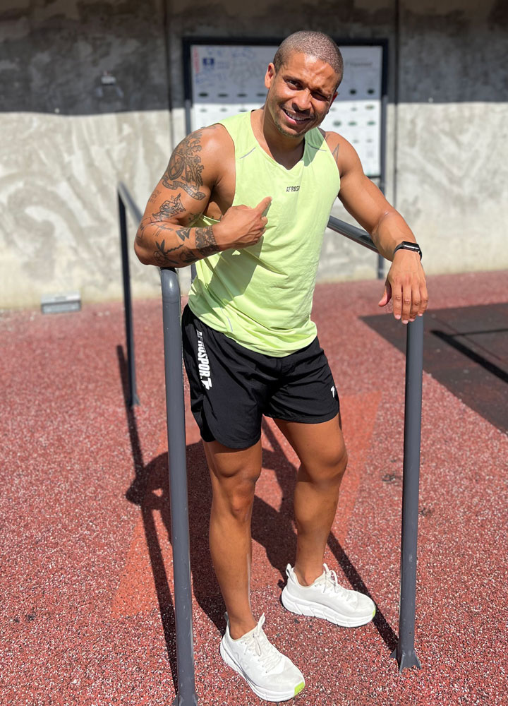 An image of the coach posing outside
