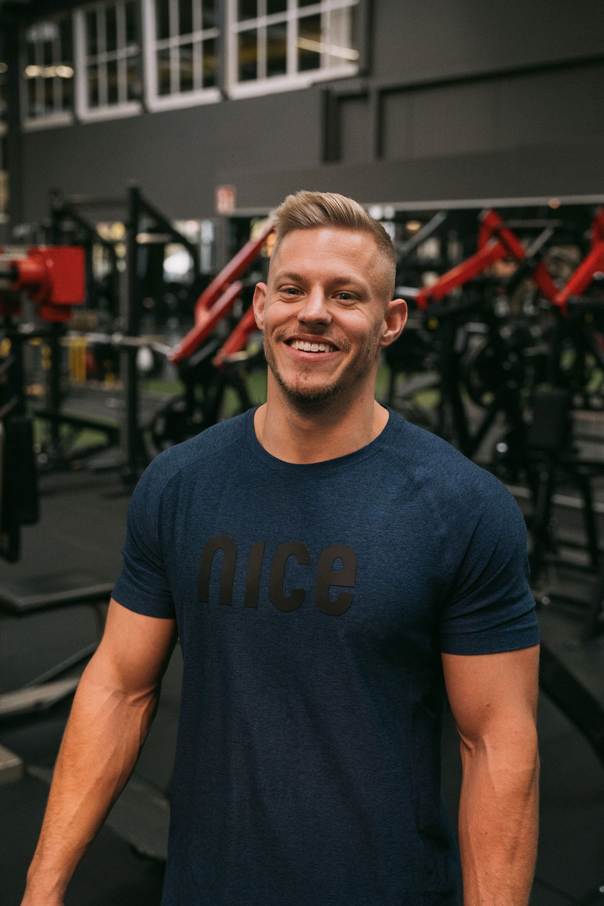 Die Coaches stehen im Fitnessstudio und lächeln.