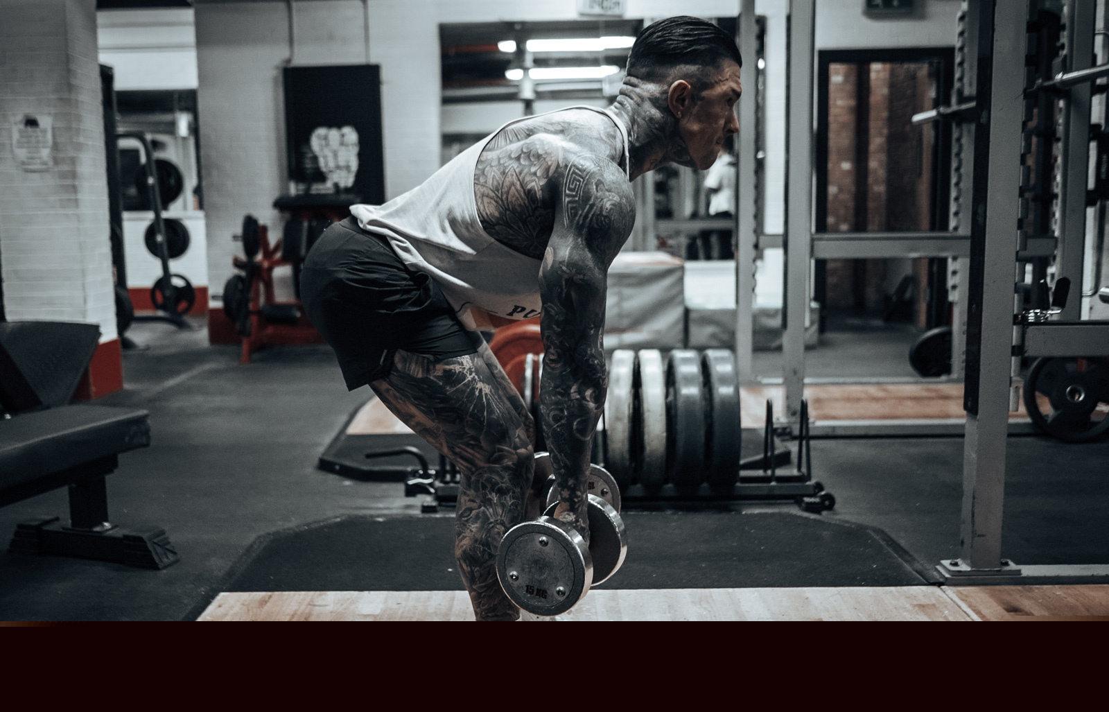 An image of coach Andrew lifting weights at a gym