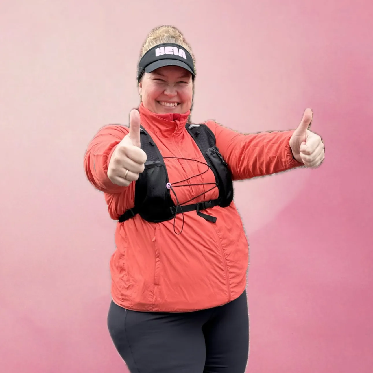 Coachen gir tommel opp med begge hender, iført løpevest.